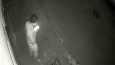 BURSA'DA BİR SİTENİN ÖNÜNDE CEP TELEFONUNA BAKARAK YÜRÜYEN GENÇ, KAPAĞI